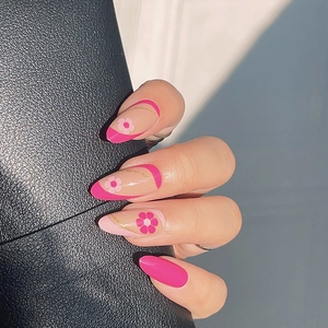 Almond shaped press-on nails with rose pink daisy floral patterns and golden outlines
