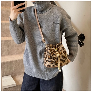 Close-up of leopard print faux fur bucket bag with gold chain and pearl pendants