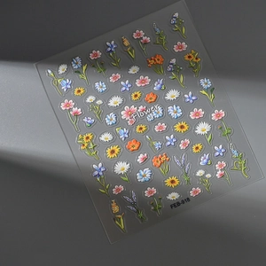 Close-up of 5D embossed floral nail stickers showing colorful 3D daisy textures