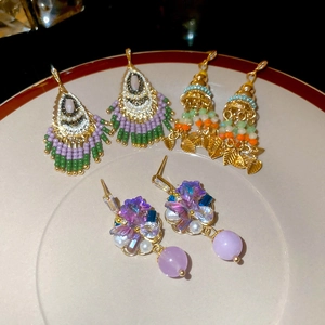 Bohemian crystal tassel and flower earrings set on a white plate with elegant details