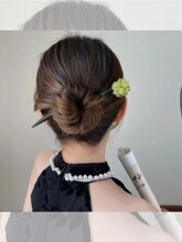 Dettaglio di un bastoncino per capelli floreale verde chiaro stile vintage