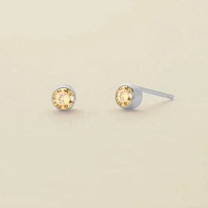Pair of minimalist silver-toned stainless steel stud earrings with yellow amber crystals