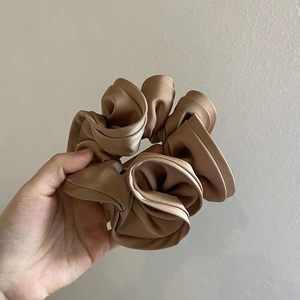 Elegant champagne silk satin scrunchie with a glossy finish and vintage ruffled design