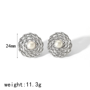 Close-up of vintage hollow silver earrings with woven floral pattern and center pearls
