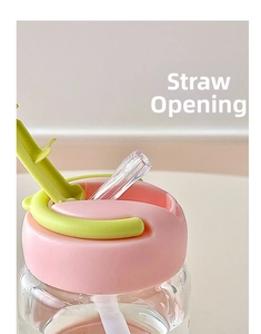 Detail of the portable glass water bottle lid with a pink cap and green straw opening