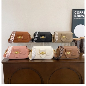 Détail de sacs bandoulière rétro colorés avec larges bandoulières tissées et boucles dorées