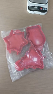 Detailed view of red plastic 3D Christmas tree and star cookie cutters in clear packaging