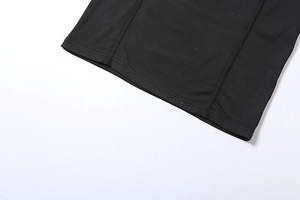 Détail de l'ourlet à double couture et texture du tissu noir sur la robe en mesh