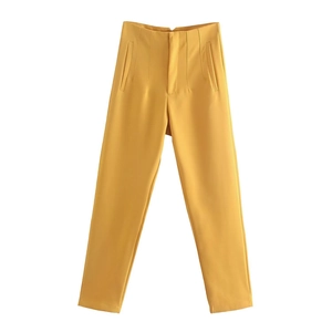 Dettaglio macro dei pantaloni a vita alta giallo senape con cuciture e tasche laterali