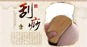Macro shot of polished sandalwood gua sha massage tool with smooth edges and natural wood grain