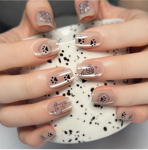 Detailed close-up of nude pink cat-eye press-on nails with cute bear and floral patterns