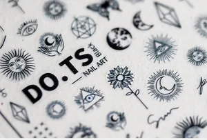 Detailed macro of 5D nail art stickers with black celestial sun, moon, and eye designs