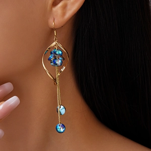 Detail of elegant gold twisted fringe earrings with blue crystal clusters on model