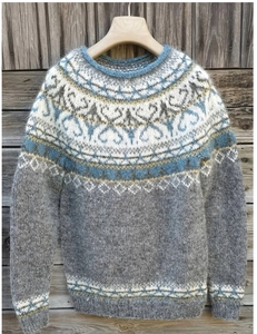 Detail van grijs, blauw en wit Fair Isle-breipatroon op een losse trui met ronde hals