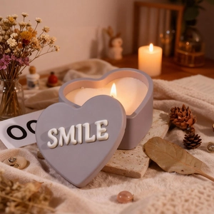 Dettaglio di una candela a cuore viola con testo Smile in rilievo sul coperchio
