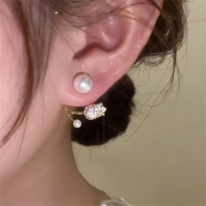 Close-up of elegant tulip pearl drop earrings with sparkling zircon inlay on the ear