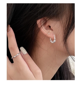 Detailed close-up of S925 sterling silver twisted hoop earrings and engraved ring set