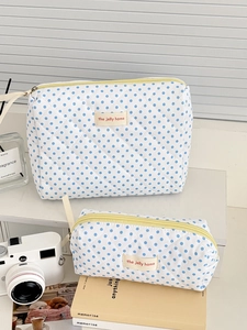Detail of quilted makeup bags with blue polka dots and a bright yellow zipper puller