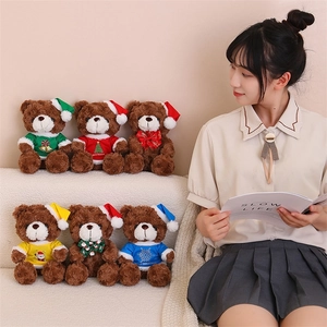 Detailed set of six Christmas teddy bears in colorful sweaters held by a model on sofa