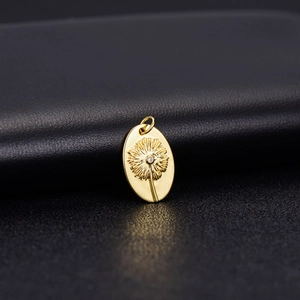 Pendente vintage in oro 14K con dente di leone e zircone su fondo di pelle nera
