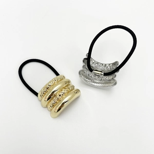 Detail of gold and silver textured metal hair rings with high elasticity black rubber bands