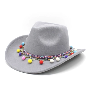 Détail chapeau de cowboy gris avec ruban ethnique coloré et pompons festifs suspendus