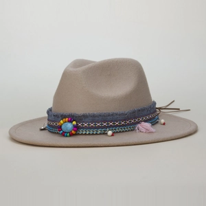 Close-up of ethnic woven band with turquoise stone and tassel on khaki wool felt hat