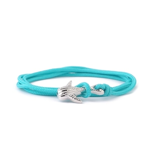 Blue nylon milan cord bracelet with silver manta ray charm on white background