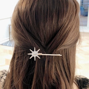Nahaufnahme einer goldenen Sternen-Haarklammer mit glitzernden Steinen im Haar
