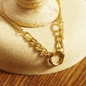 Collana a catena dorata minimalista con un ciondolo circolare irregolare e strutturato