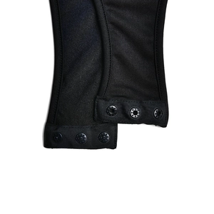 Detail shot of black bodysuit bottom featuring secure snap button closure and fabric texture