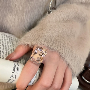 Macro shot of an oversized emerald cut pink crystal square ring on model's hand