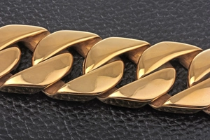 Macro shot of polished 18k gold plated stainless steel Cuban link bracelet for men
