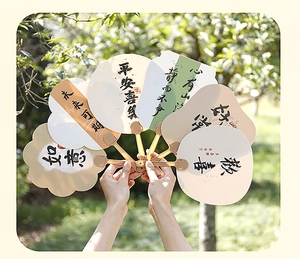 Close-up of Chinese calligraphy fans with auspicious phrases in a lush garden setting