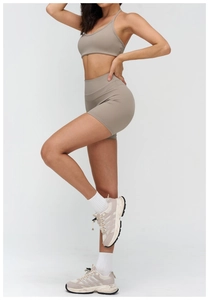 Side view of beige ribbed yoga set featuring thin strap sports bra and high waist shorts