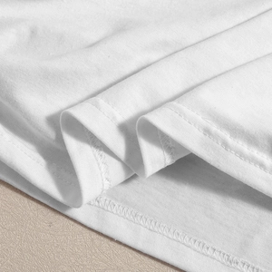 Détail de l'ourlet de la robe blanche en maille avec couture à double aiguille