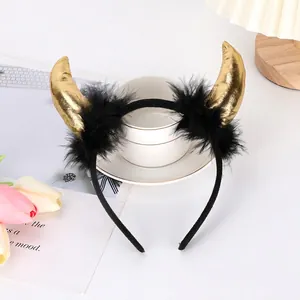 Golden devil horn headband with black feathers on a cozy white desk setup