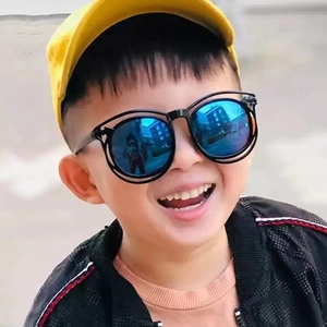 Cute boy wearing double-bridge round kids sunglasses with blue polarized lenses