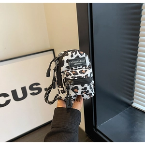 Mini leopard print crossbody bag detail with fashion tag and woven lanyard close-up