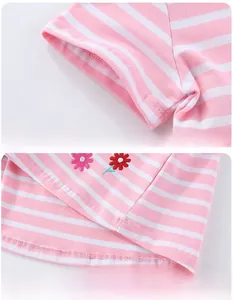 Détail du tissu en maille rayé rose et blanc avec des broderies de fleurs colorées