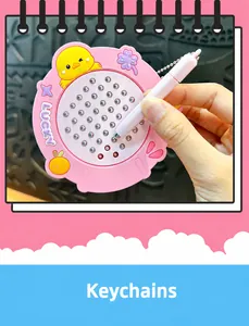 Detail view of pink duck magnetic steel ball drawing board keychain toy held by hand
