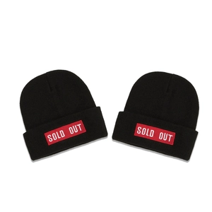 Two black knitted beanies featuring red SOLD OUT embroidery patches for winter fashion