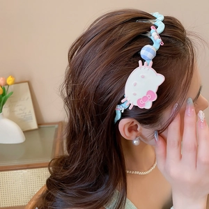 Detail of blue knitted wavy headband with cute cat character and colorful beads