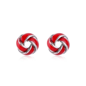 Close-up of red enamel and silver metal knot stud earrings with polished finish
