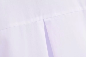 Gros plan du dos d'une chemise en coton avec coutures précises et détail de pli