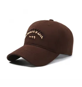 Detail of 3D embroidery and cotton fabric texture on dark brown baseball cap