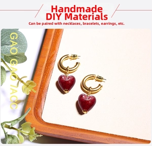 Detail of dark red heart glass pendant with gold metal hoop for DIY jewelry making