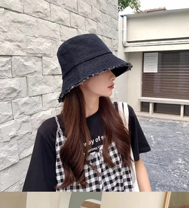 Détail du chapeau bob en denim noir avec bords effilochés pour un style tendance