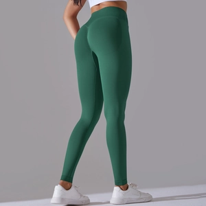 Detail view of seamless dark green yoga pants showing cross-waist and peach lift effect
