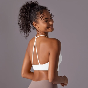 Detailed view of white yoga bra featuring a delicate criss-cross back strap design
